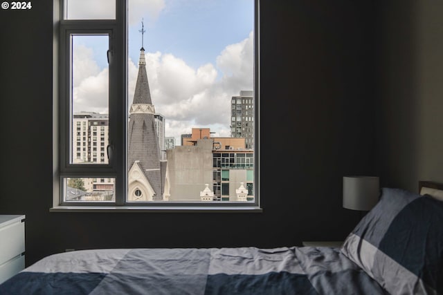 bedroom with a city view and multiple windows