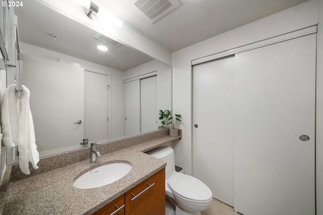 bathroom featuring toilet, visible vents, and vanity