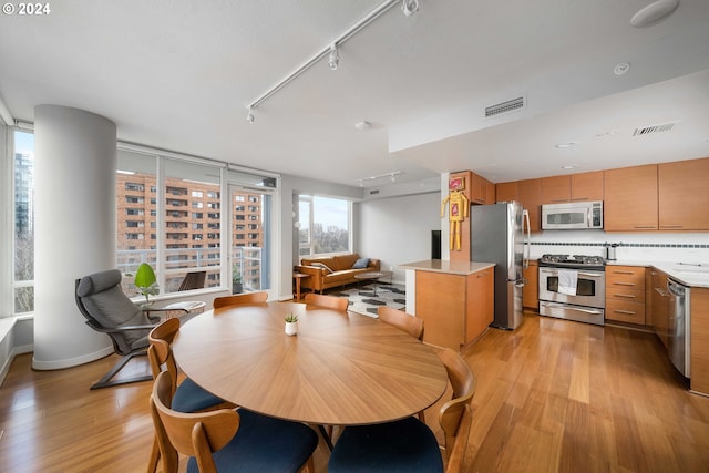 dining room featuring light wood-style flooring, visible vents, and track lighting