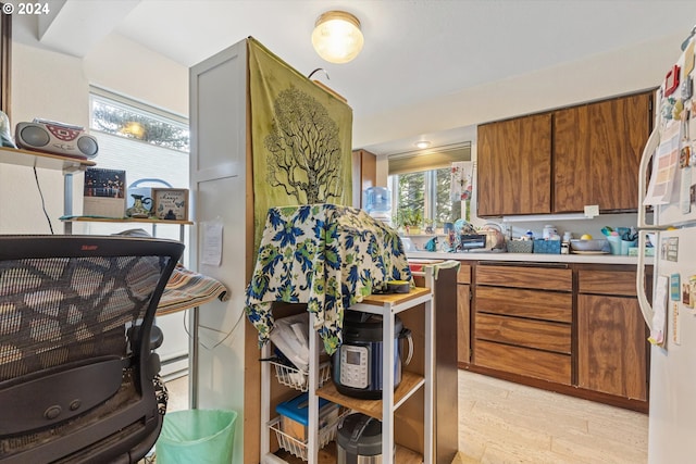 kitchen featuring baseboard heating, white refrigerator, and light wood-type flooring