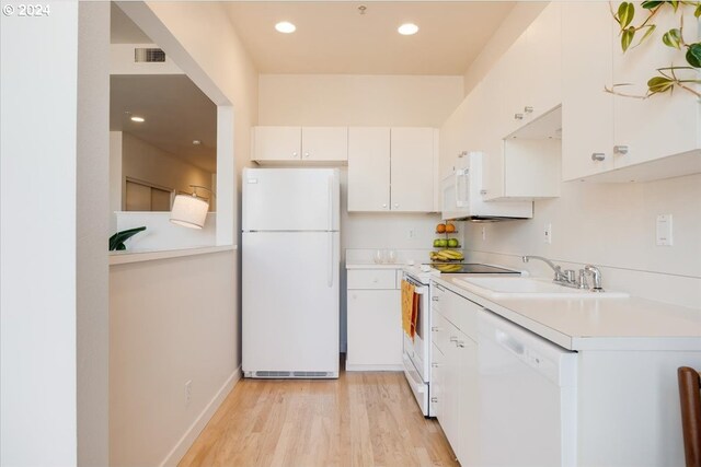 kitchen with light wood-type flooring, sink, white appliances, and white cabinets