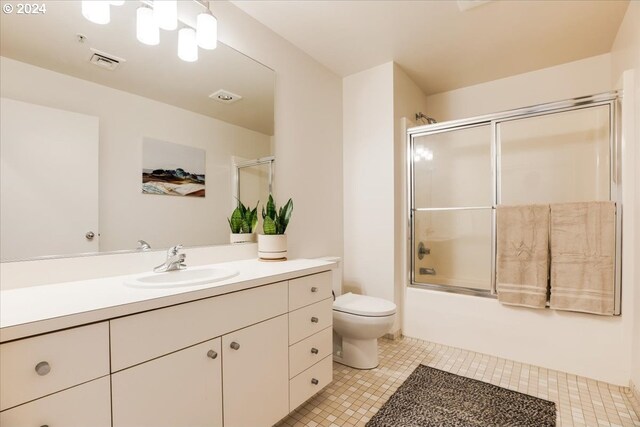 full bathroom featuring tile patterned flooring, shower / bath combination with glass door, toilet, and vanity