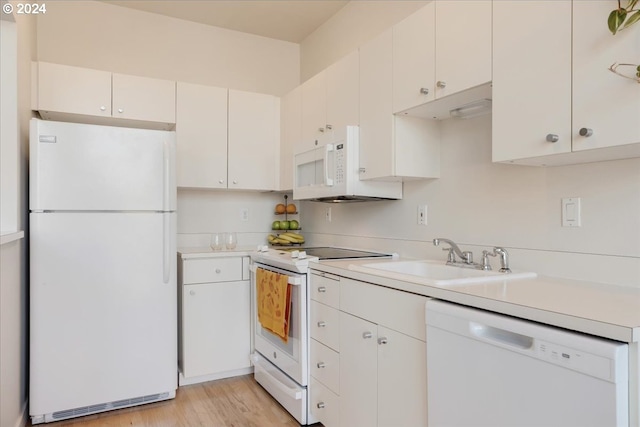 kitchen with white cabinets, light wood-type flooring, sink, and white appliances