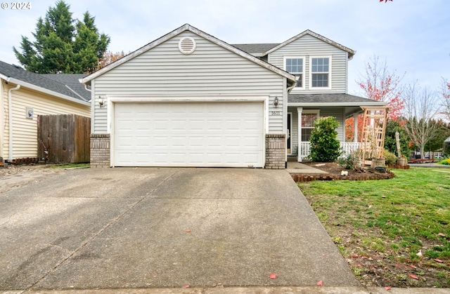 front of property featuring a garage, covered porch, and a front yard