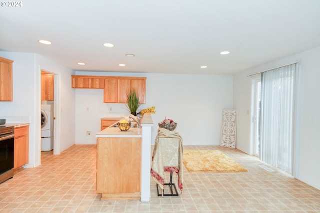 kitchen with washer / clothes dryer, sink, and stainless steel range with electric stovetop