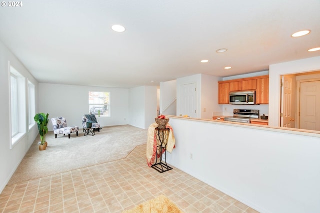 kitchen featuring light colored carpet and appliances with stainless steel finishes