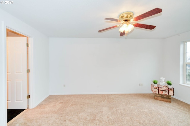 carpeted spare room with ceiling fan