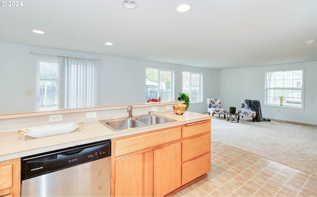 kitchen with sink, light carpet, light brown cabinets, stainless steel dishwasher, and plenty of natural light