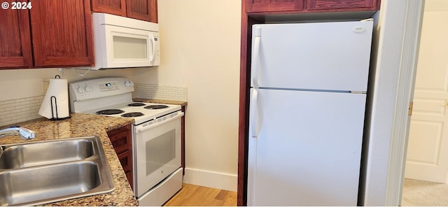 kitchen with sink, light stone counters, backsplash, white appliances, and light wood-type flooring