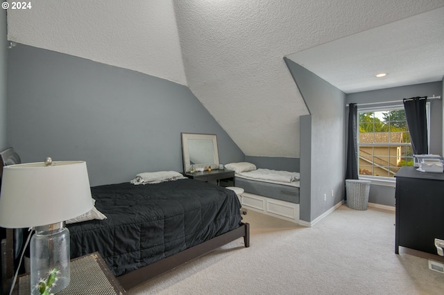 bedroom featuring a textured ceiling, lofted ceiling, and light colored carpet