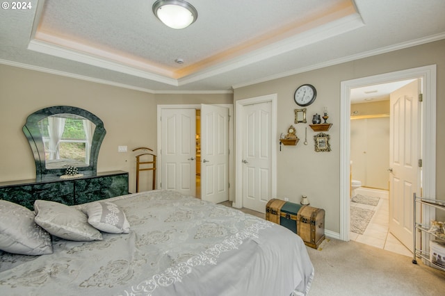 bedroom featuring connected bathroom, a raised ceiling, light colored carpet, and crown molding