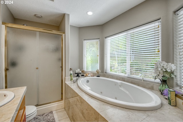 full bathroom featuring plus walk in shower, a textured ceiling, tile patterned floors, vanity, and toilet