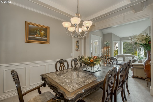 carpeted dining space featuring ornamental molding, a chandelier, and vaulted ceiling