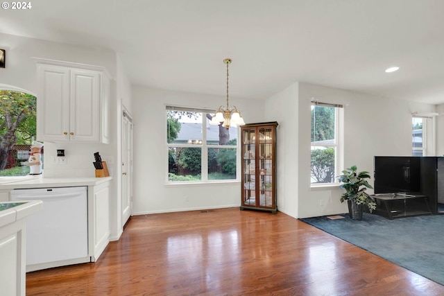 kitchen with white cabinets, an inviting chandelier, white dishwasher, light wood-type flooring, and pendant lighting