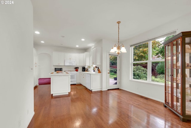 kitchen featuring hardwood / wood-style floors, pendant lighting, an inviting chandelier, white cabinets, and white appliances