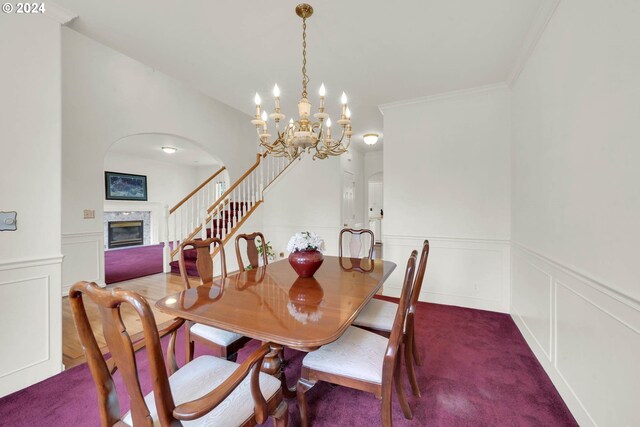 carpeted dining space with ornamental molding and a chandelier