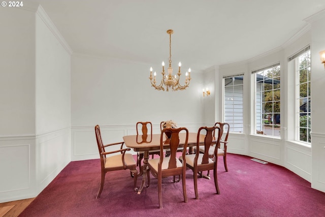 dining room with carpet, a notable chandelier, and ornamental molding