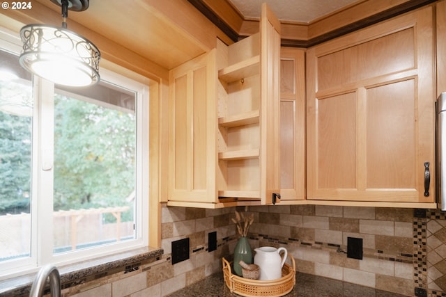 kitchen with light brown cabinetry and tasteful backsplash