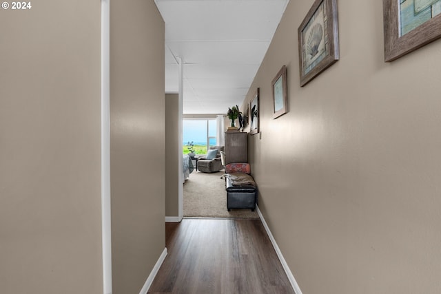 hallway with dark wood-style flooring and baseboards