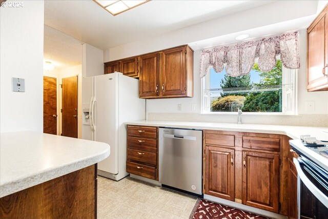 kitchen featuring dishwasher, stove, light tile patterned floors, and white fridge with ice dispenser