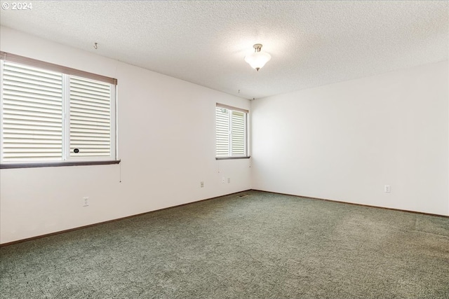 carpeted spare room featuring a textured ceiling