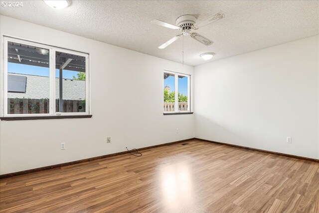 unfurnished room featuring ceiling fan, a textured ceiling, and hardwood / wood-style floors