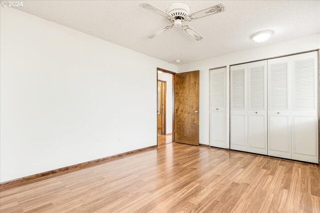 unfurnished bedroom featuring ceiling fan, light wood-type flooring, and a textured ceiling