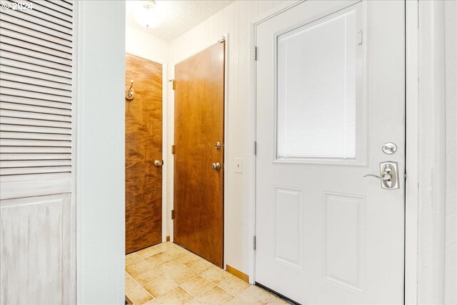 doorway with light tile patterned flooring