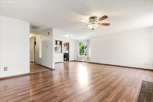 unfurnished living room featuring a textured ceiling, hardwood / wood-style floors, and ceiling fan