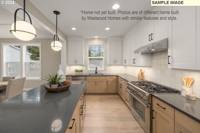 kitchen featuring white cabinets, decorative light fixtures, sink, and appliances with stainless steel finishes