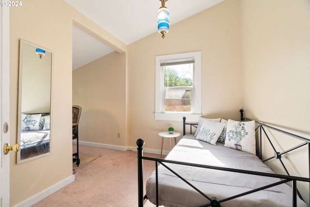 bedroom with lofted ceiling, light carpet, and baseboards