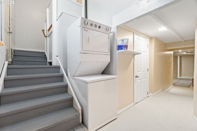 interior space with baseboards and stacked washer / drying machine