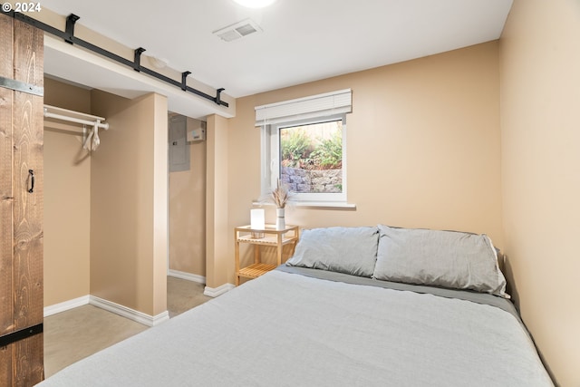 bedroom featuring visible vents, baseboards, and a barn door