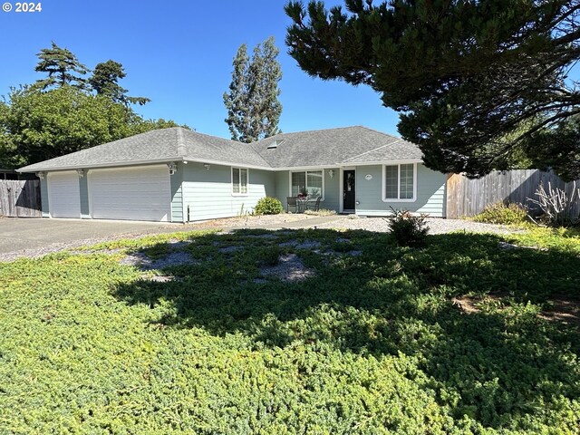 ranch-style home with a garage and a front lawn