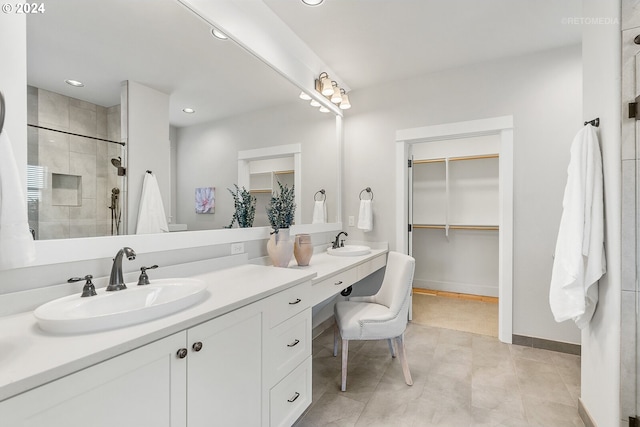 bathroom featuring vanity, a shower with shower door, and tile patterned flooring