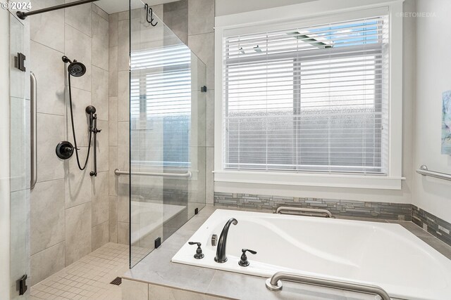 bathroom featuring shower with separate bathtub