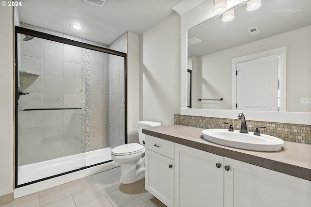 bathroom featuring decorative backsplash, a shower with door, vanity, and toilet