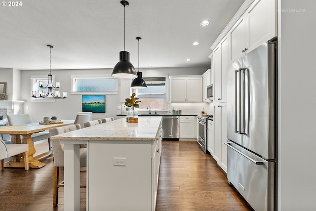 kitchen featuring dark hardwood / wood-style floors, high end appliances, white cabinetry, and a center island