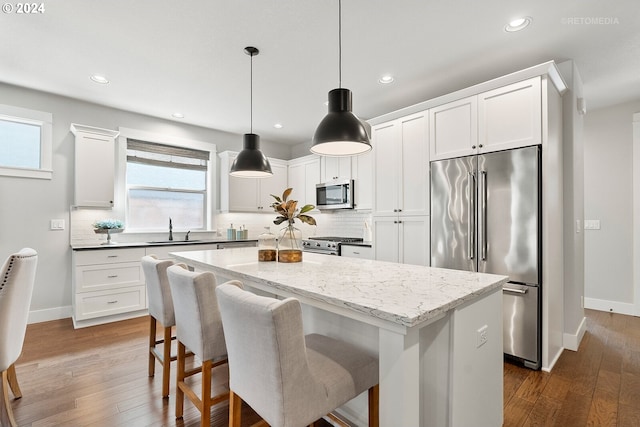 kitchen featuring a center island, dark wood-type flooring, sink, high end appliances, and backsplash