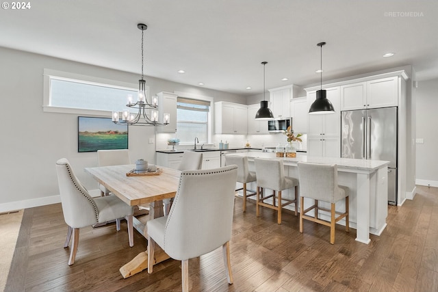 dining area featuring a notable chandelier, sink, plenty of natural light, and dark wood-type flooring