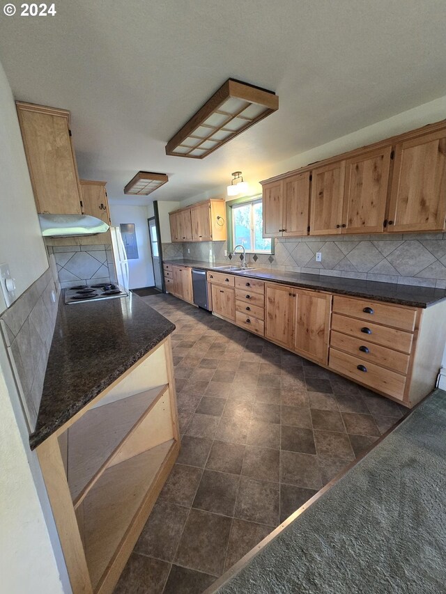 kitchen with backsplash, dishwasher, sink, and dark tile patterned flooring