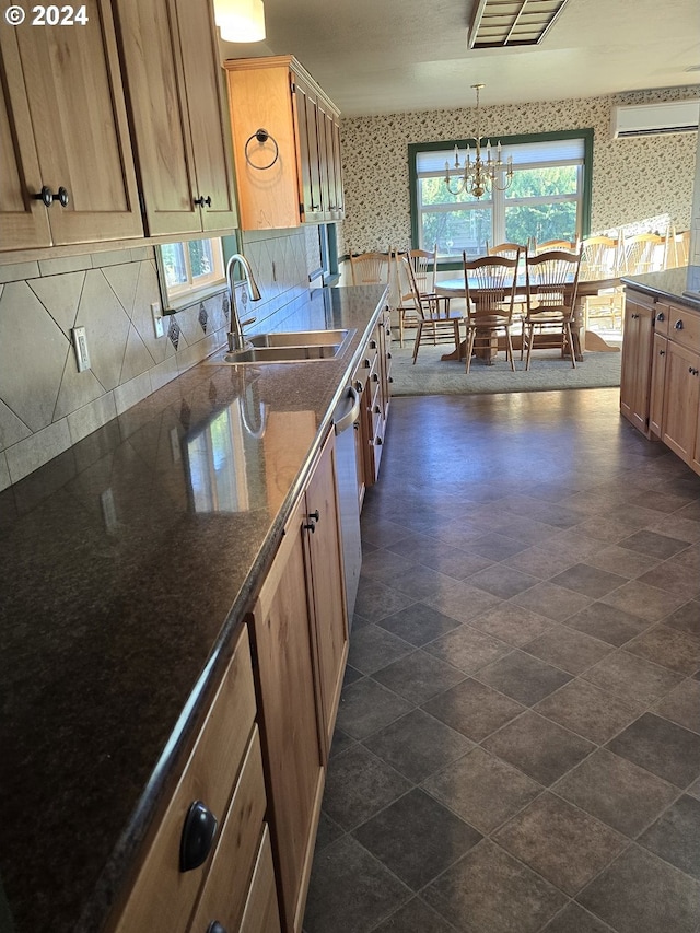 kitchen featuring sink, pendant lighting, decorative backsplash, and an inviting chandelier