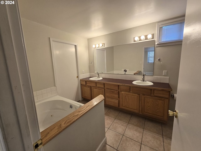 bathroom with tile patterned flooring, a tub, and vanity