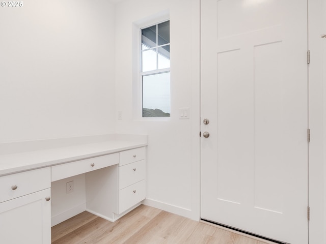 interior space featuring built in desk and light hardwood / wood-style floors