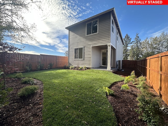 back of property with a yard and a patio