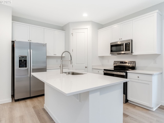 kitchen with sink, stainless steel appliances, light hardwood / wood-style floors, an island with sink, and white cabinets