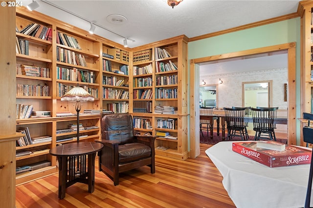 sitting room with crown molding, hardwood / wood-style floors, and a textured ceiling