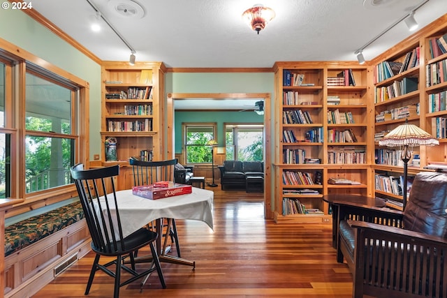 interior space featuring crown molding, track lighting, hardwood / wood-style floors, and built in features