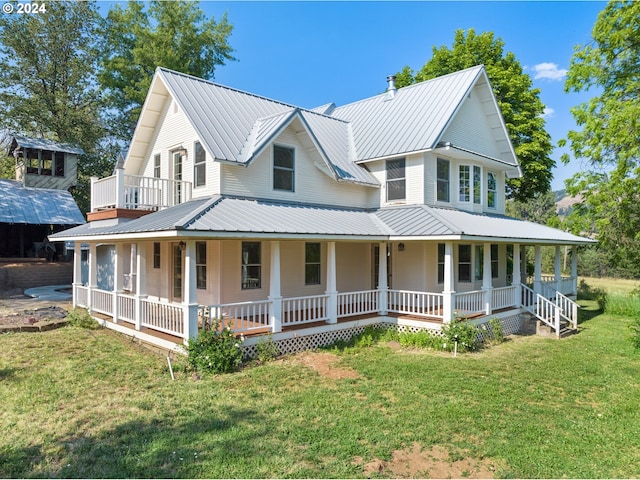 farmhouse featuring a front lawn and covered porch