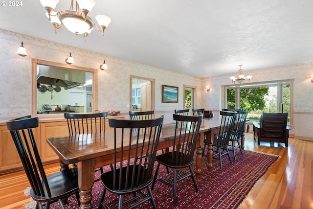 dining space featuring light wood-type flooring and an inviting chandelier